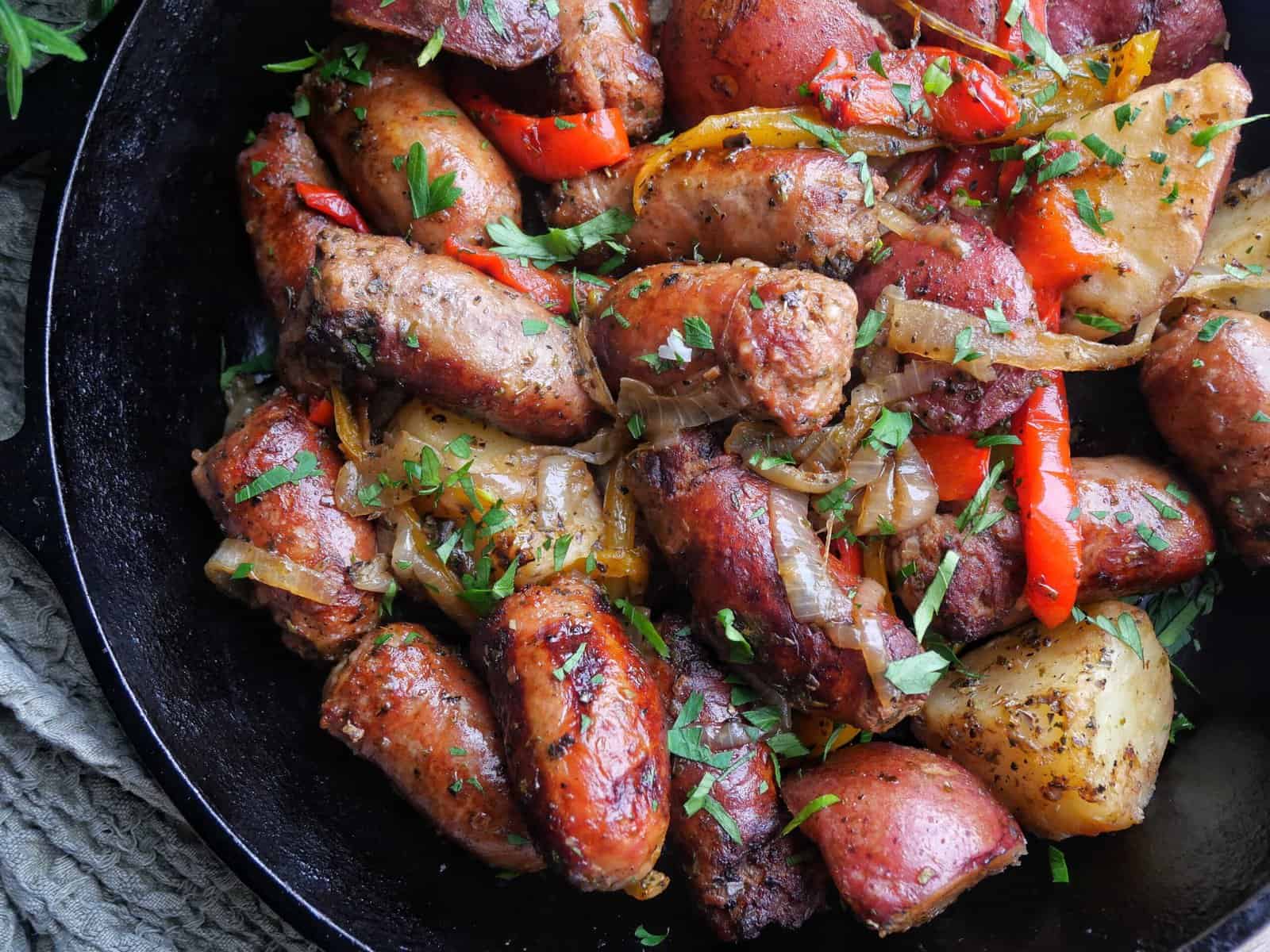 sausage peppers and potatoes in a cast iron skillet